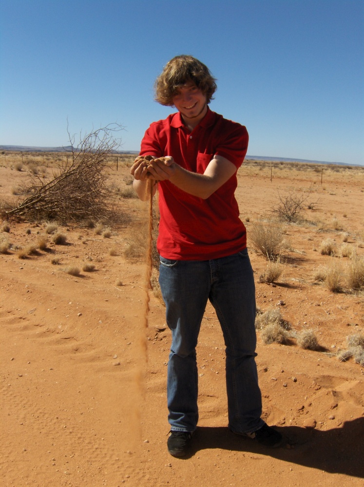 Tobi rieselt Sand durch die Finger